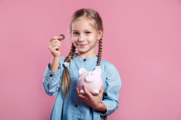 Little girl saving money in a piggybank on pink studio background Short Term Loans Online, Short Term Cash Loans, Online Short Term Personal Loans